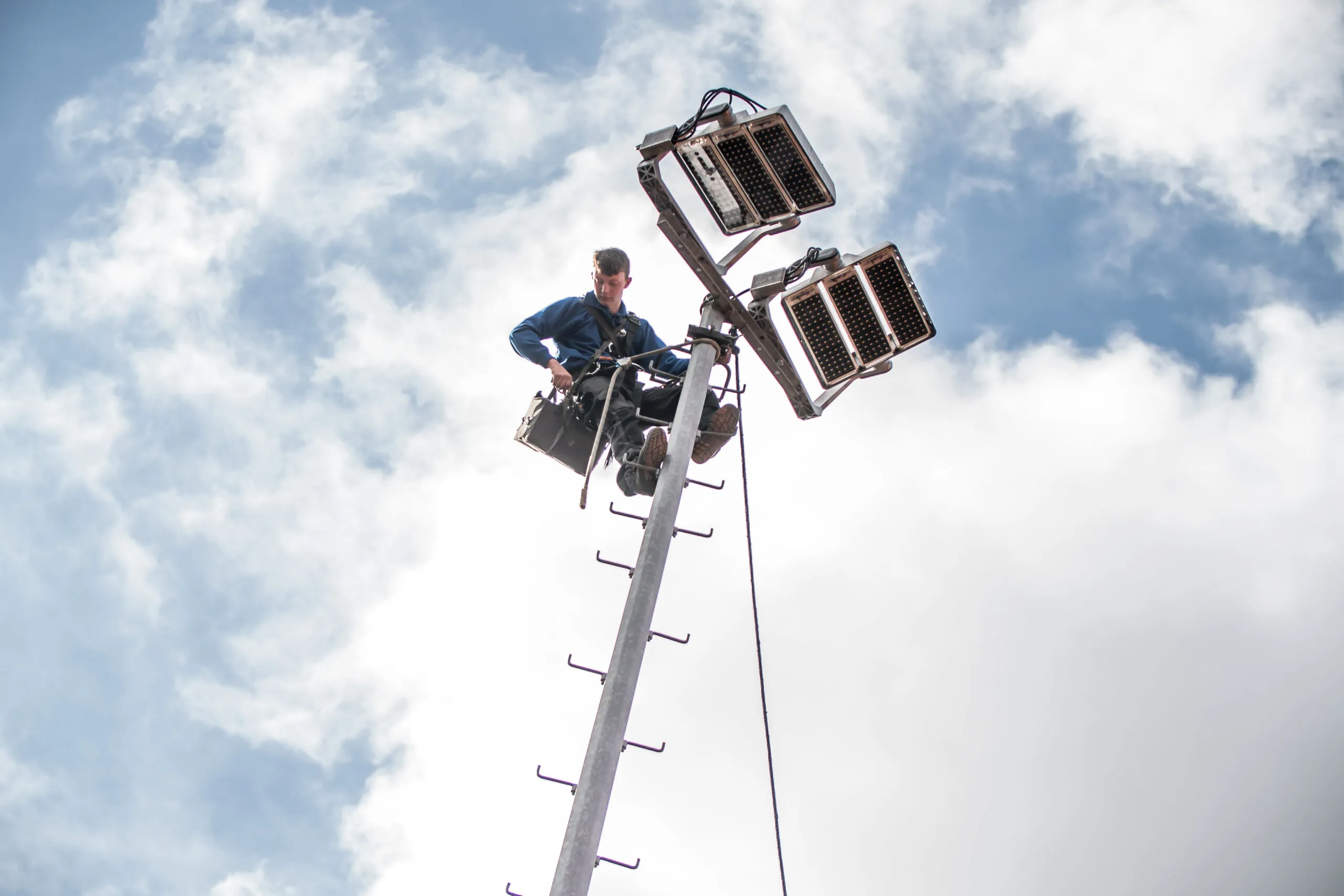 Ger Adrichem van OVI aan het werk bij een LED-schijnwerper bovenin een lichtmast